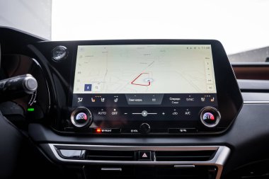 Gündüz iç mekanı, kırmızı rota çizgisi, çift yönlü iklim kontrolü, metalik süsleme, parlak siyah bezel ve sol üst Lexus analog saati olan manzara dokunmatik ekranını gösteriyor..