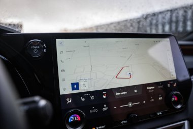 Yağmurlu bir gün görüntüsü Lexus RX 450h artı Riga, Letonya 'daki Lexus Riga Havalimanı yakınlarındaki rota, 20.0 C ve 21.0 C' de ikili bölge sıcaklıkları ve koltuk ikonları gösteriyor..