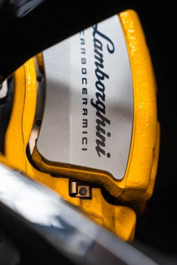 Makro yakın çekim sarı Lamborghini fren kalibreli gümüş takılı CARBOCERAMICI metin, çerçeve tekerlek donanım, sığ alan derinliği ve karamsar ışıklandırma.