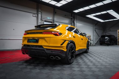 Arka üç çeyrek görüntü dört egzozlu, dağınık, siyah kanatlı ve açısal arka farları gösteriyor. Dama döşemesi ve parlak ışıklandırma bile özel siyah tekerlekleri yansıtıyor.