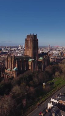 Hava gündoğumu, Liverpool Katedrali 'nin merkez kulesini gösteriyor. Kamera, Radyo Şehir Kulesi, rıhtım vinçleri, yol trafiği, ağaçlar ve sıcak sabah ışığı ile yükseliyor..