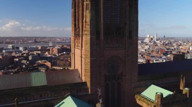 Hava aracı Liverpool Katedral Kulesi 'nden şehrin ufuk çizgisine yeşil çatılar ve Mersey Nehri' nden dönme dolap, Radyo Şehir Kulesi, vinçler ve feribotlar ile gündoğumunda geçecek..