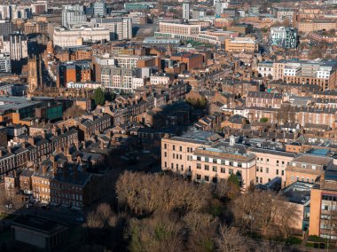 İngiltere 'nin orta Liverpool şehrinde hava gündoğumu, St. Luke' un kilise kulesini, tuğla terasları, modern apartmanlar, kurumsal bloklar ve uzun gölgeli kışlık çıplak ağaçları gösteriyor..