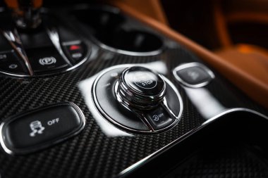 Kapalı gösteriler krom başlatma düğmesi, sürücü modu seçici, çekme kontrolü kapalı, otomatik başlatma stop off, park freni, ve kahverengi deri kaplama bardak tutucu.