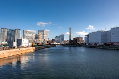 Liverpool 'daki sakin liman havzası, modern binalar Stanley Dock Tütün Deposu bacası, kış ışığı ve durgun su yeni ufuk çizgisini yansıtıyor..