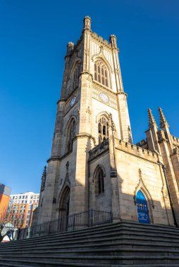 Liverpool 'daki St. Luke' s Bombalanmış Kilisesi dimdik ayakta, saat yüzleri ve çentikler görünür, geniş adımlardan alçak açı, kemerli pencereler ve kapı aralığı kış detaylarını gösteriyor.