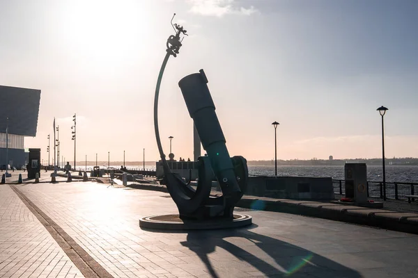 Gün batımında Liverpool rıhtımı Liverpool Teleskop heykelini, ark, Mersey, sokak lambaları, Liverpool Müzesi, Pier Head ve kış ışığı üzerindeki bisikletçiyi gösteriyor..
