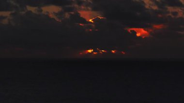 Fuerteventura açıklarındaki Atlas Okyanusu üzerindeki hava manzarası, fırtına bulutları güneşin arka ışıkları kayarken engin bir mürekkep denizi ve alçak ufuk üzerindeki erimiş turuncu patlamalarla yer değiştiriyor..