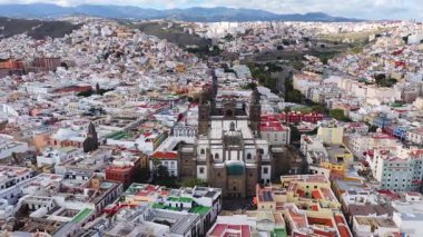 Las Palmas 'ın çatıları ve Santa Ana Katedrali' nin dar caddeleri üzerinde uçan tencere. Ufukta Teide Dağı, gün ışığı, arabalar ve insanlar yakınlarda hareket ediyor..