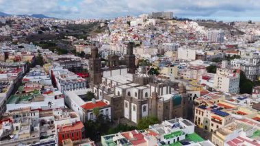 Hava 4K tavaları ve inişleri Vegueta, Las Palmas 'taki Katedral de Santa Ana' yı gösteriyor, ikiz kuleler, beyaz ve taş cephe, dar sokaklar, plazalar, güneş panelleri, Teide Dağı.