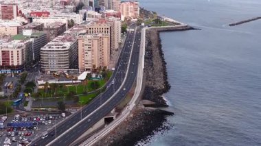 Hava görüntüsü Las Palmas, Avenida Maritima, kaya yatağı, yükselen daireler, La Luz Limanı, feribotlar, yelkenliler, park, arabalar, dalgalar ve ufukta Teide görünüyor..