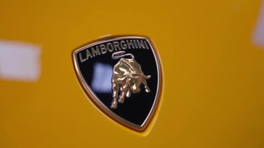 Dar makro Lamborghini kalkanını sarı bir panele yerleştirir. Pürüzsüz tavalar ve askılar metalik gölgeler ortaya çıkarır ve kapalı bir stüdyoda kaplamalı bir kaplama oluşturur..