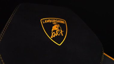 Siyah Alcantara başlığı sarı Lamborghini kalkanı ve boğa, altıgen form, sarı dikişler, yavaş tava ve ince zum stüdyo ışığı, sığ alan derinliği