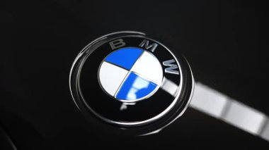 Işıltılı siyah BMW yuvarlak yansıtıcı kaput merkezli oturur kamera yavaş yavaş iterek, eğerek ve askı altında odaklanır kapalı bir galeride gündüz boyunca.