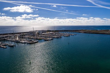 Arrecife yakınlarındaki Lanzarote marinasının havadan görünüşü yelkenliler, yatlar, kıvrımlı dalgalar, düzenli rıhtımlar, liman binaları, şamandıralar, zıtlıklar ve gün ortasında turkuaz suyu..
