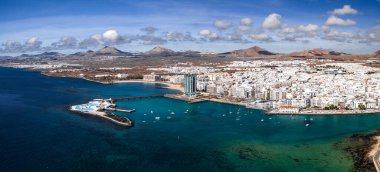 Arrecife, Lanzarote, marina, gezinti güvertesi, Gran Hotel Arrecife, Islote de Fermina havuzları, aquamarine körfezleri, koyu lav kıyıları ve koyu renkli volkanik koni ile hava manzarası..