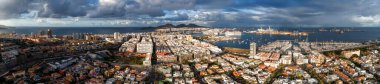 Las Palmas de Gran Canaria 'nın havadan görünüşü, Las Palmas Limanı yolcu gemileri, kargo vinçleri ve liman direkleri, La Isleta tepeleri, ve bir turkuaz liman üzerinde öğleden sonra ışığı..