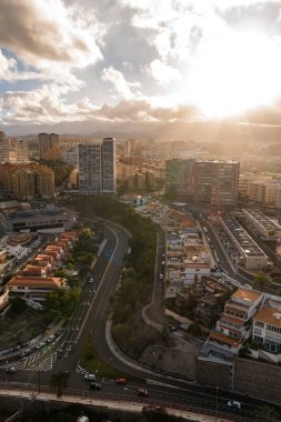 Las Palmas de Gran Canaria 'daki hava şehirleri S eğrisi çok şeritli yolları, yüksek binaları, teraslı blokları, kış güneşlerini, dağları ve yaya trafiğini gösteriyor..