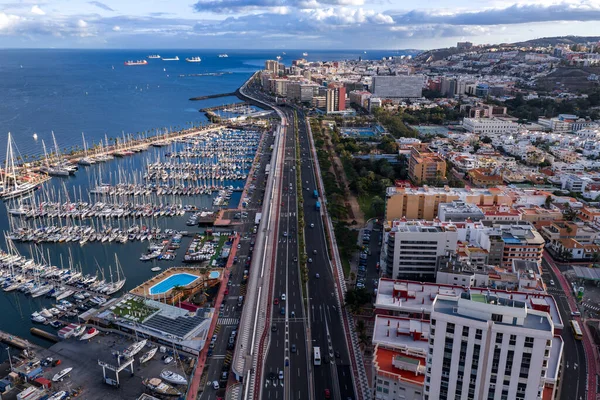 Las Palmas de Gran Canaria 'nın hava görüntüsü, öğleden sonra ışık altında yelkenli ve yat marinası, mavi yüzme havuzu, gezinti güvertesi, kargo gemileri ve iskele vinçlerinin yanında GC 1' i gösteriyor..