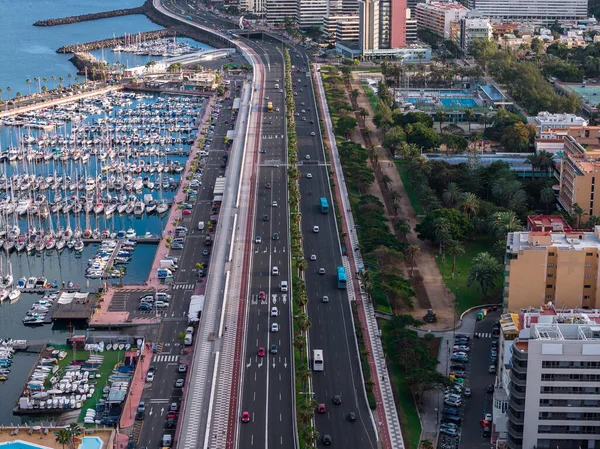 Las Palmas de Gran Canaria 'nın öğleden sonraki görüntüsünde Muelle Deportivo yelkenlileri, Avenida Maritima yolları, kırmızı ve beyaz bisiklet yolları, park, mahkeme ve Atlantik yakınlarındaki kuleler görülüyor..