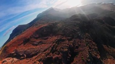 Hava kamerası Lanzarote 'deki Risco de Famara' yı süpürüyor, öğleden sonra geç saatlerde derin dereler, kayalık kayalar, Atlantik kıyıları ve güneşli sahil şeritleri boyunca süzülüyor.