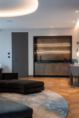 Çağdaş apartman dairesi, bar bölmesinde metalik paneller ve sıcak LED raf aydınlatması, kıvrımlı kömür bölümü ve akşam saatlerinde herringbone ahşap döşemeleri olan bir bina sunar..