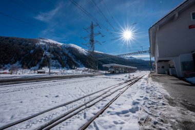 Kar, dar gösterge hatlarını kapatarak Zermatt istasyonunda üst hatları, modern beyaz bir bina, sütunlar ve Matterhorn bölgesine bakan bir yol tüneli oluşturur..