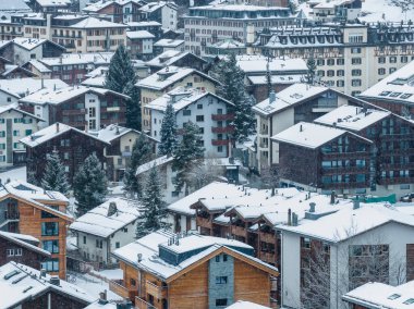 Zermatt, İsviçre 'nin hava manzarası, taze kar altında Chalet ve lüks oteller, dik çatılı çatılar, kırmızı kepenkler, koyu renk keresteler, yumuşak sabah ışığı gösteriyor..