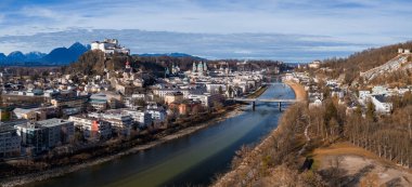 Salzburg, Avusturya 'nın havadan görünüşü, Salzach Nehri, köprüler, Hohensalzburg Kalesi ve Salzburg Katedrali, yumuşak kış ışığı ve uzak karlı Alpler altında..