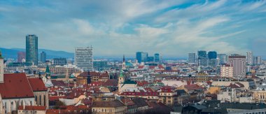 Slovakya 'nın Bratislava kenti, St. Martin Katedrali, Eurovea ve Nivy cam kuleleri, kırmızı çatılı tarihi bloklar ve sakin gündüz vakti Küçük Karpatlar gösteriyor..
