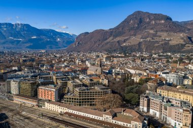 İtalya 'nın Bolzano kentinin hava manzarası, açık bir günde Gotik Bolzano Katedrali' ni, terasotta çatılarını, demiryolu tersanesini ve Monte Tondo ve Dolomite eteklerinin altındaki istasyonu gösteriyor..