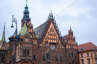 Wroclaw 's Old Town Hall on the Rynek gables, clock ve kuleleri gösterir, önünde altın küreler ile işlenmiş bir demir lamba, yumuşak ışık ile kapalı bir günde.