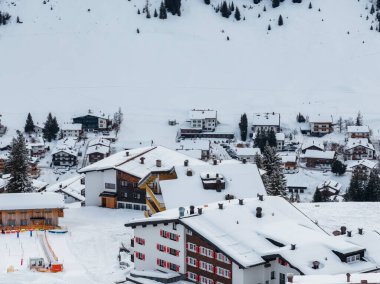 Hava sahnesinde kırmızı kepenkleri, gablı çatıları, bacaları ve Avusturya 'nın Lech ve Oberlech kentlerinde kayak alanı olan dağ evi otelleri görülüyor..