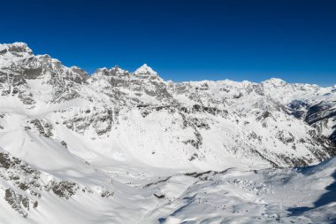 İtalyan Alpleri 'ndeki San Domenico kayak merkezini gösteriyor. Kayakçılar, asansör hatları, karlı tepeler, geniş pistler ve korunaklı bir vadide kurulu bir tatil köyü..