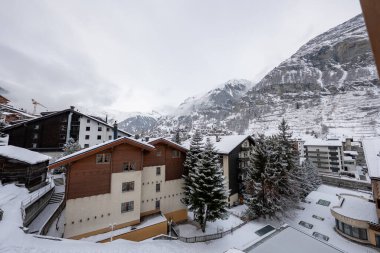 İsviçre 'nin Zermatt kentinde kar tebeşir ve otellerin dar şeritlerini kapladı. Pennine Alpleri bulutlu bir kış gününde dimdik yükseliyor. Hafif ışık ve serin tonlarda..