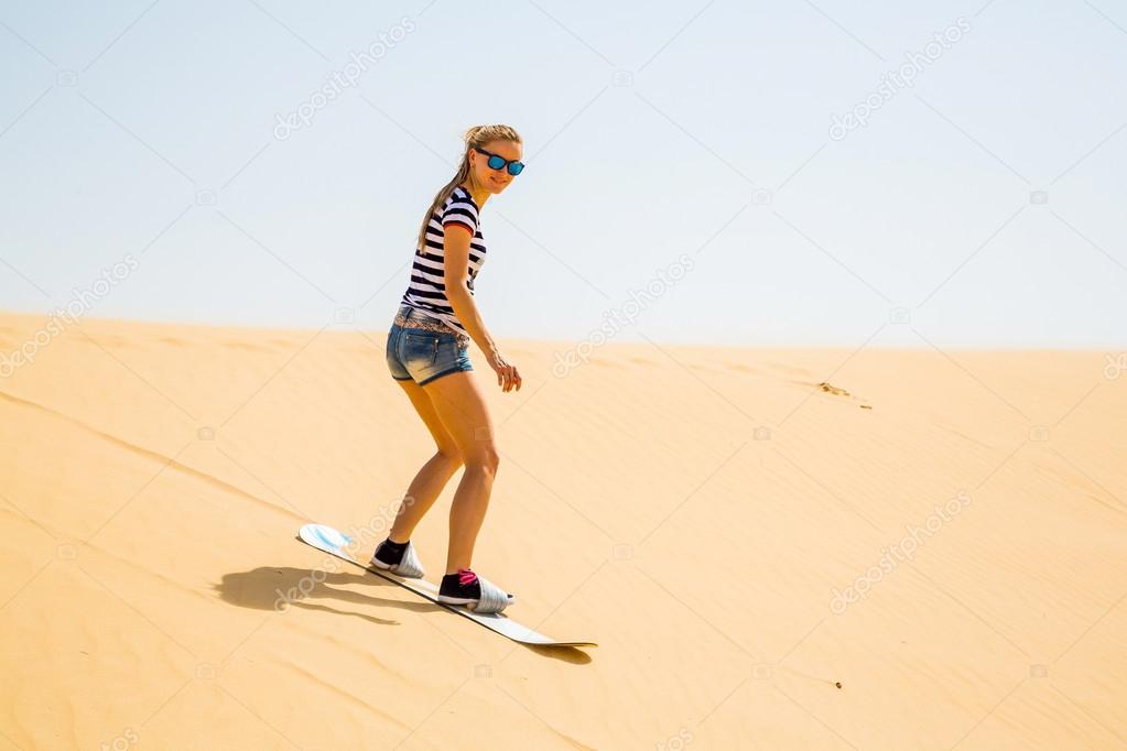 Sand boarding at the beach from a dune