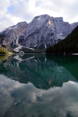Montagne e nuvole riflesse nel lago alpino