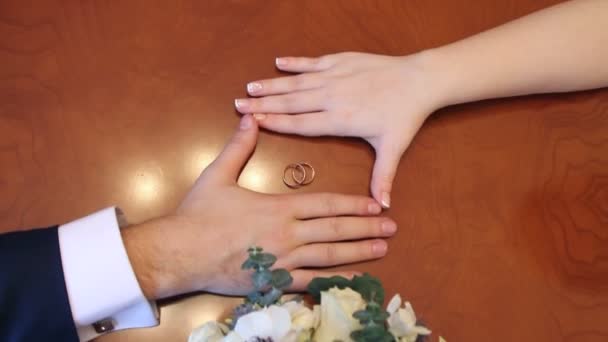 Hands of bride and groom and wedding rings — Stock Video