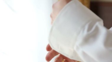 Onun gömlek kelepçeleri damat düğmeleri