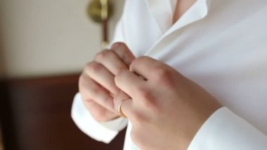 Onun gömlek kelepçeleri damat düğmeleri