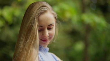 Genç bir kadının çekici gülümsemesi, güneşli bir günde zevki yansıtan gözleri..