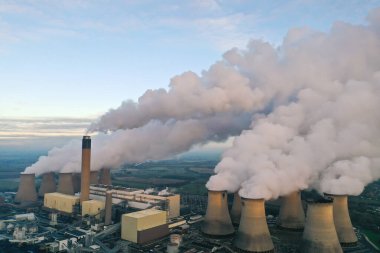 DRAX POWER İSTASYONU, YORKSHIRE, İngiltere - 7 Ocak 2021. Drax Kömür Ateşli Enerji İstasyonu 'nun bacasından ve soğutma kulelerinden buhar ve duman pompalarken yenilenemez elektrik üreten hava manzarası.