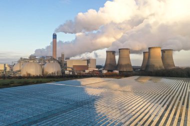 DRAX POWER İSTASYONU, YORKSHIRE, İngiltere - 7 Ocak 2021. Drax Elektrik Santrali 'nin bacasından buhar pompalarken ve soğutma kulelerinden duman çıkarırken ısıtılan seralardan aşırı ısı kullanan yenilenemez elektrik üretirken görüntüsü.
