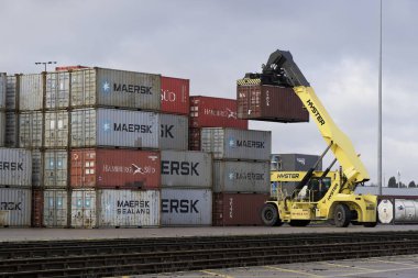 DONCASTER RAILPORT, DONCASTER, İngiltere - 29 HAZİRAN 2021. İngiltere 'ye ihracat ve ithalat için bir nakliye veya kargo konteynırı istiflemekte olan ağır bir kaldırma makinesi