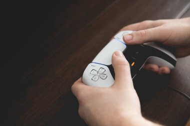 SELBY, UK, MARCH 11, 2021.  Close up of a pair of male hands using and playing with a Playstation PS5 controller handset with copy space