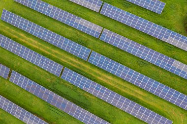 Güneşin temiz ve yenilenebilir enerjisini kullanan sıra sıra güneş panellerinin hava görüntüsü