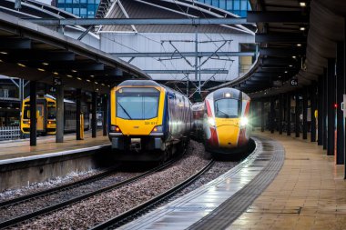 Leeds, İngiltere - 12 Aralık 2025. Leeds tren istasyonundaki yerel bir banliyö treniyle birlikte LNER Azuma çift yönlü şehirlerarası yolcu treninin ön görüntüsü.