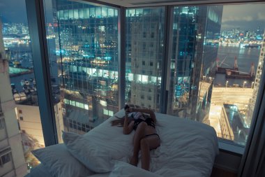 Young attractive woman making selfie in the bed at night