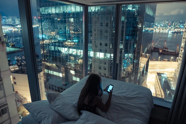 Mujer usando smartphone en la cama por la noche Fotos De Stock Sin Royalties Gratis