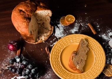 Lezzetli noel pastası panettone dilimi ve Noel süslemeleri.